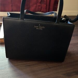 Upgrade your style with this classic Kate Spade black leather tote bag.